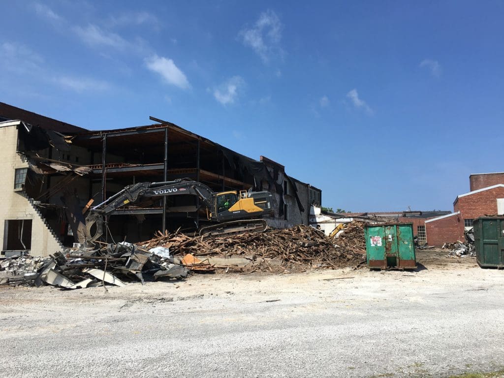 Partly demolished commercial buildings with equipment working