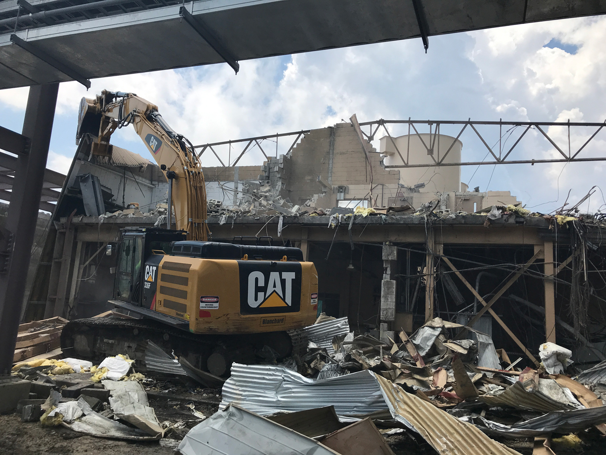Excavator tearing down a steel-framed building