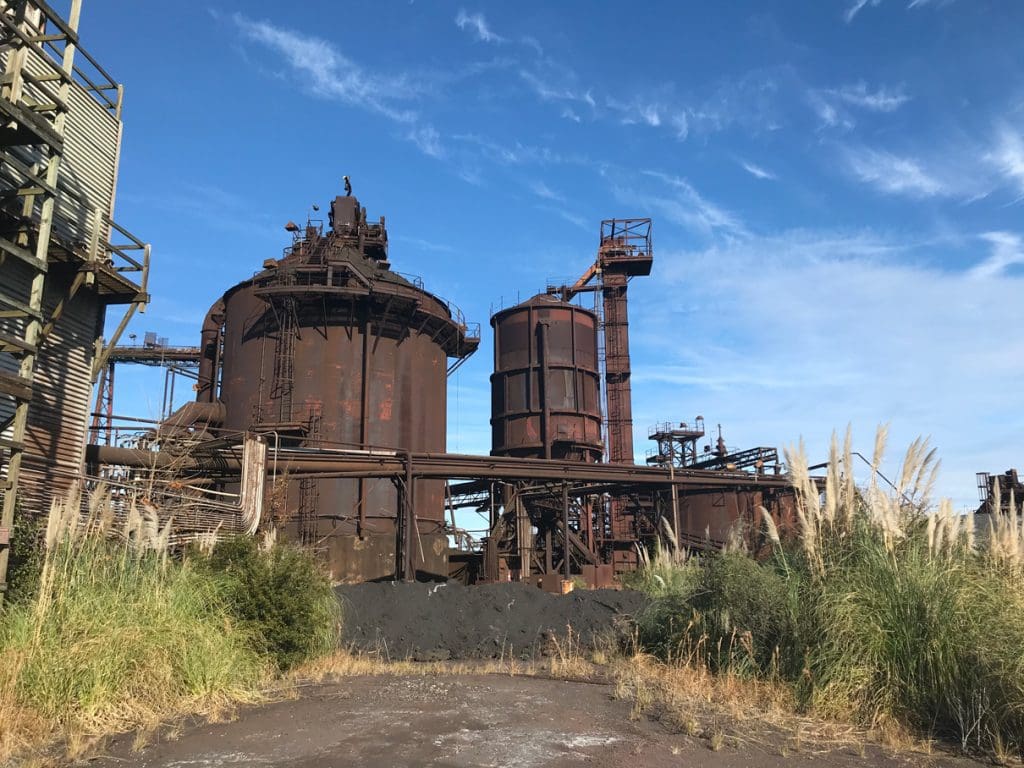 Rusted process vessels and tall structures at an industrial plant