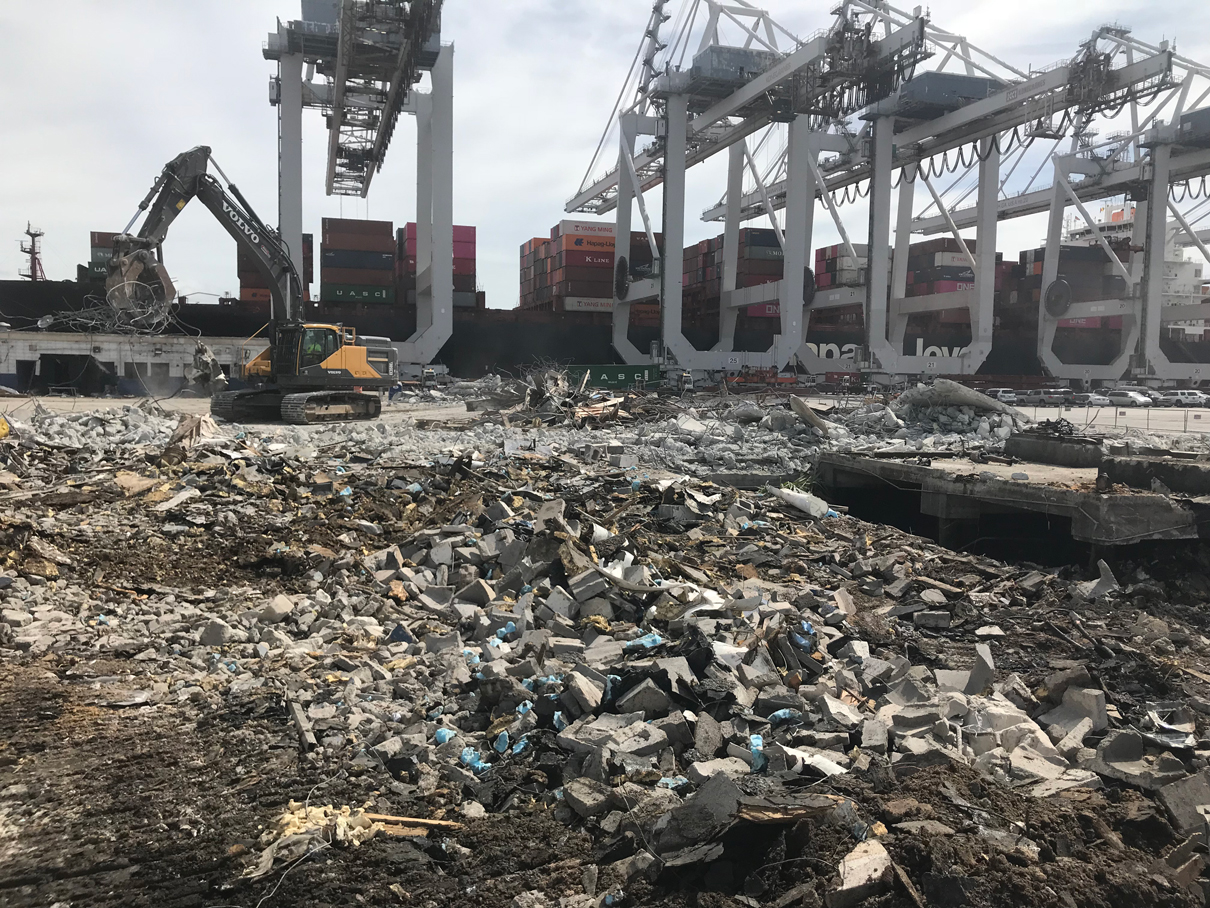 Excavators working on a pile of crushed demolition debris