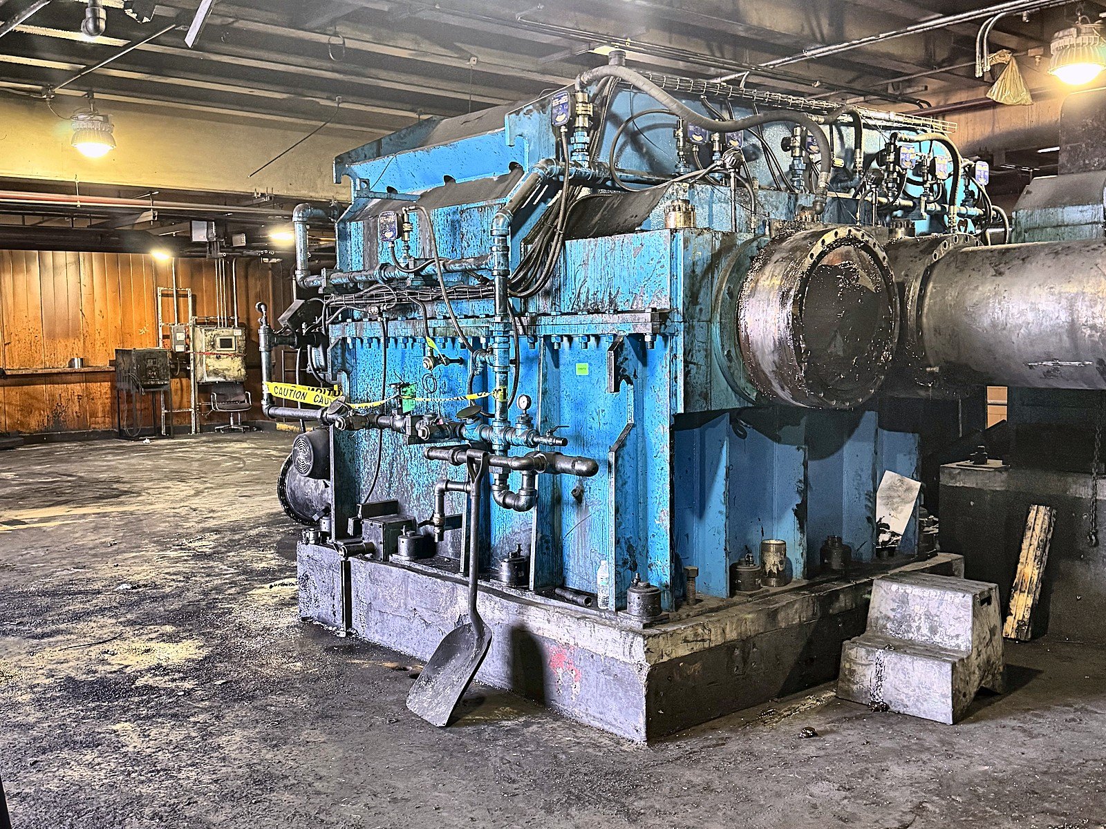 Large blue industrial gearbox and drive equipment inside a plant