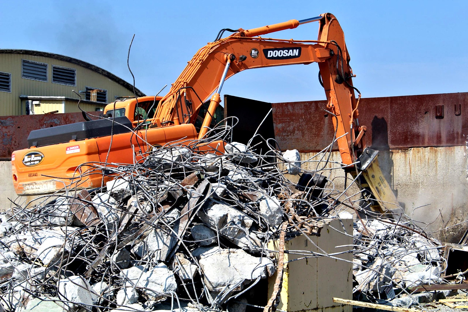 Excavator sorting crushed concrete and rebar