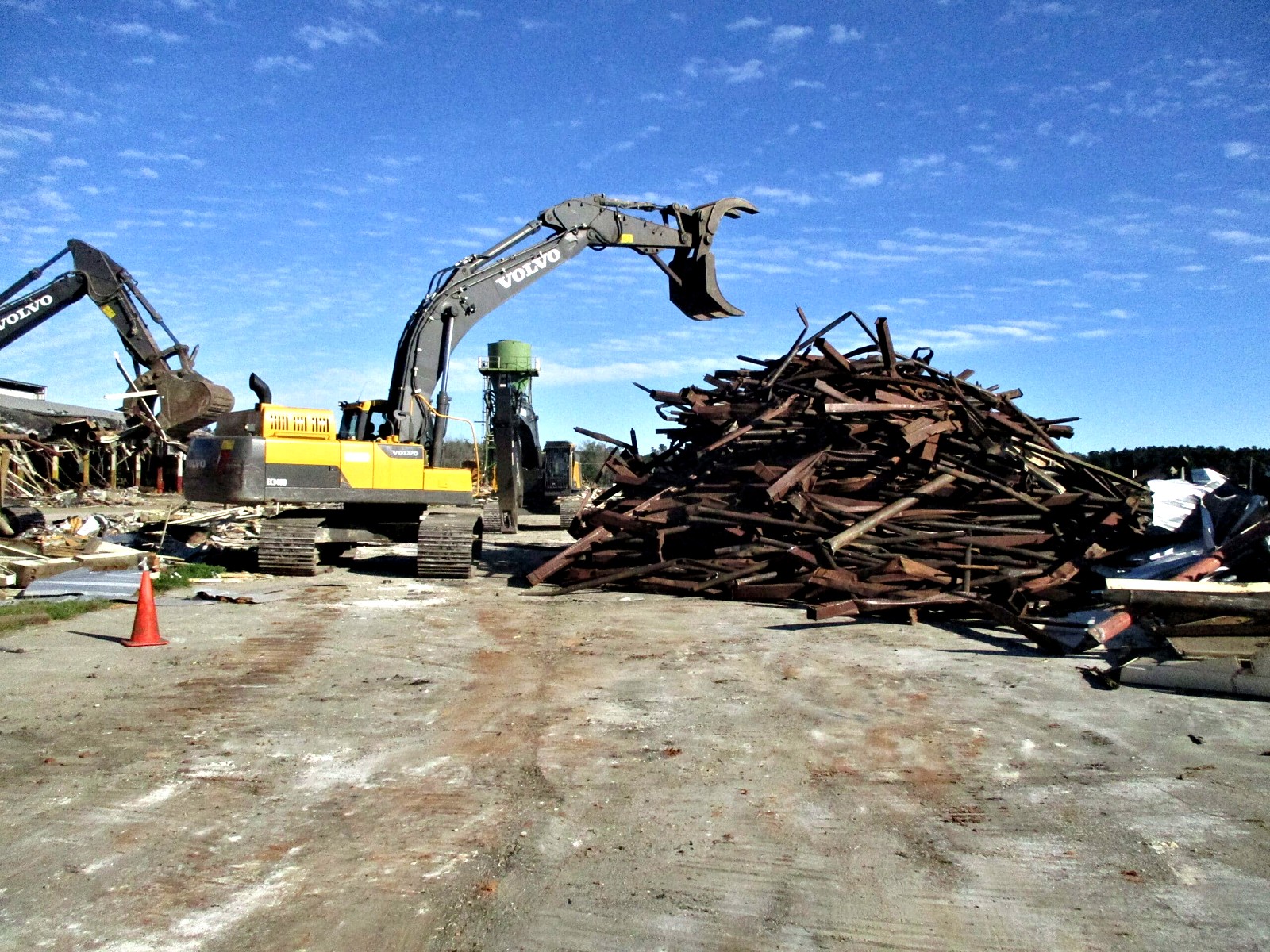 Excavators sorting a scrap pile on a demolition site