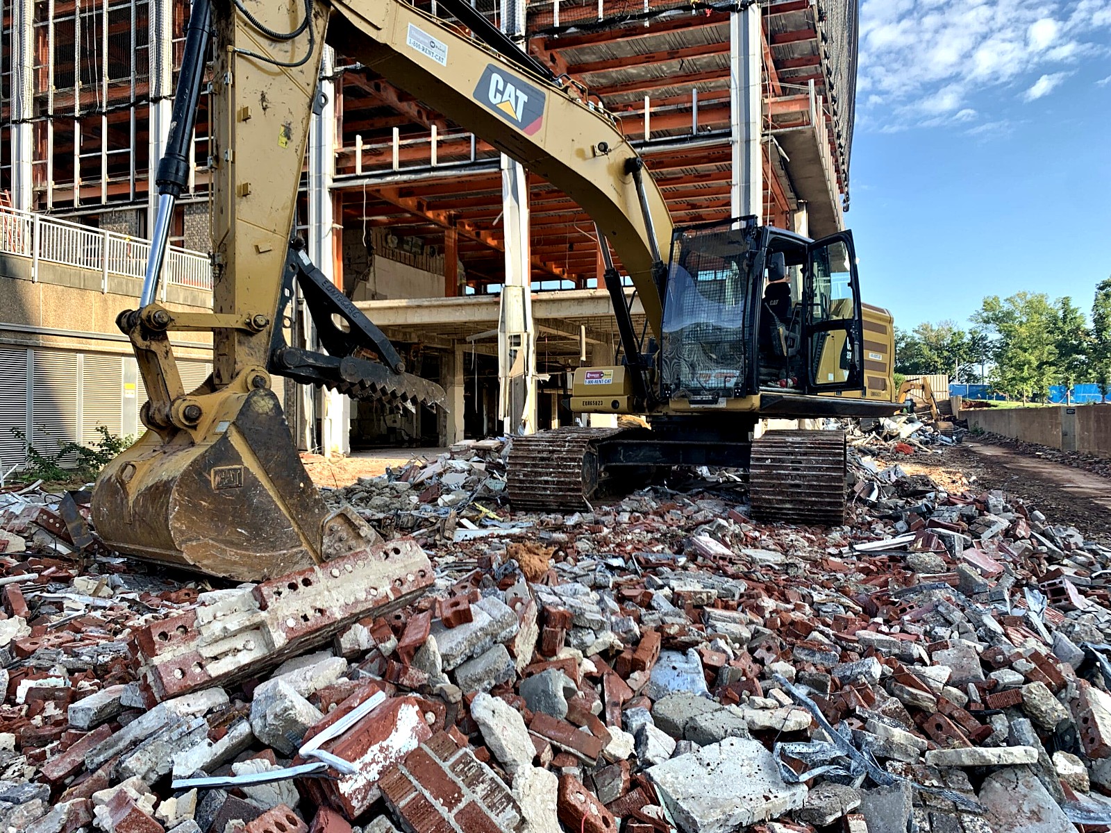Excavator clearing debris on a demolition site