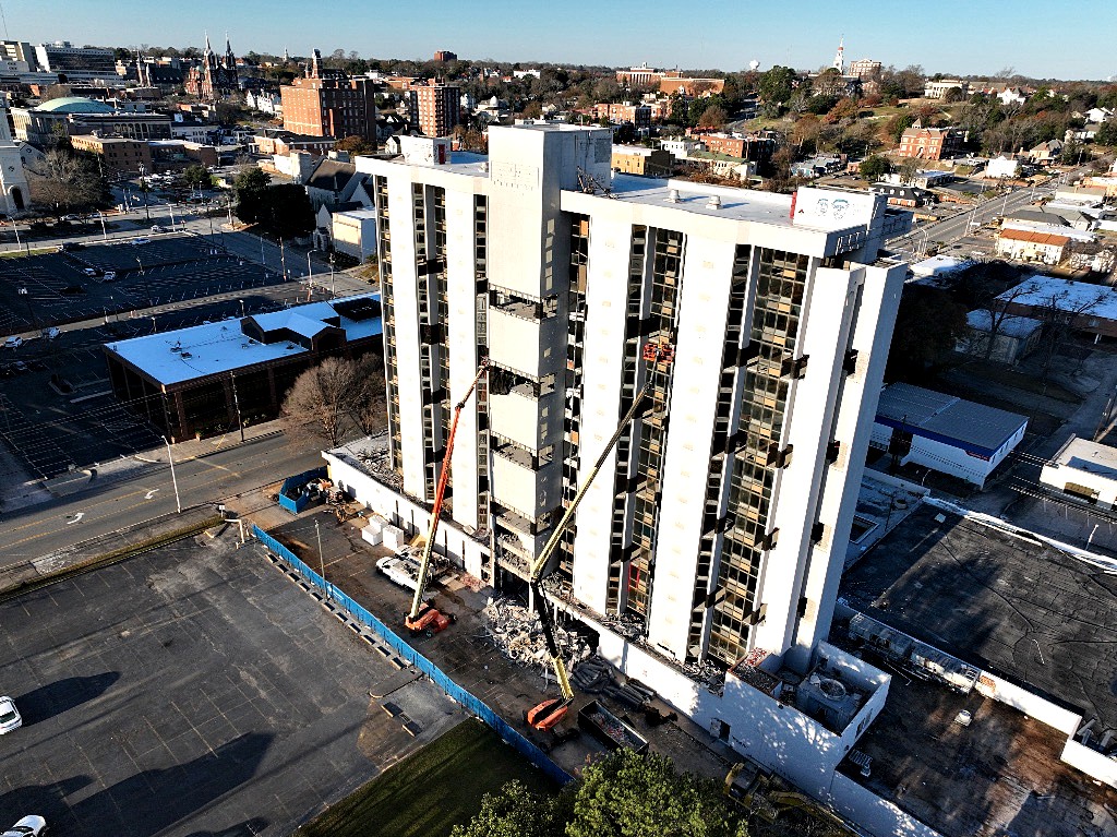 Aerial view of a high-rise demolition among neighboring buildings