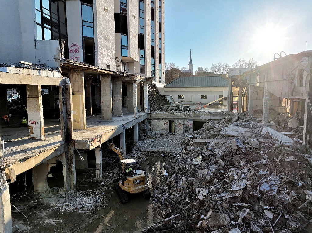 Excavators working below grade in a demolished building foundation