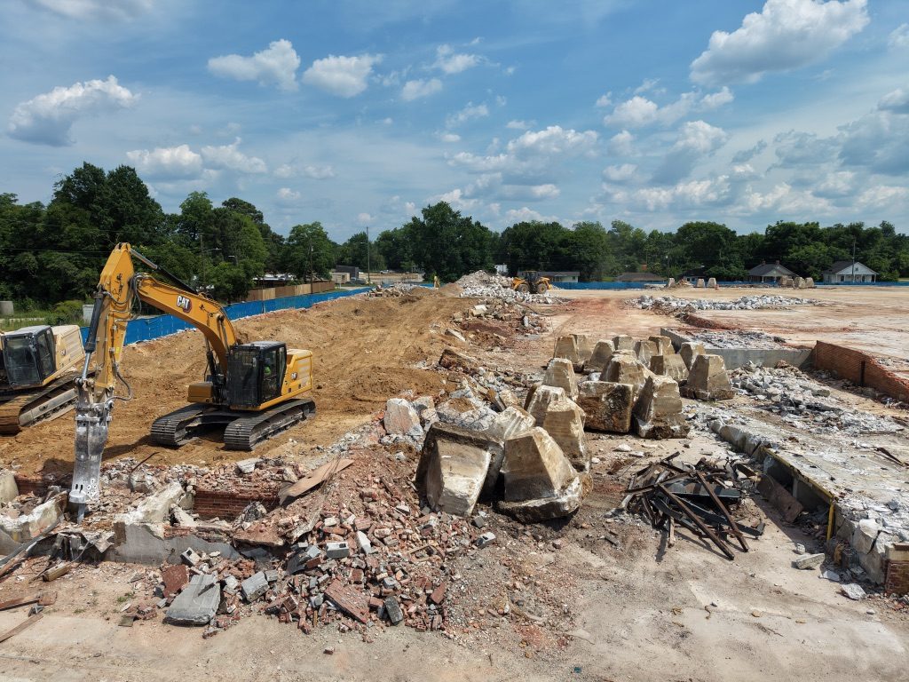 Excavator with a hammer attachment working in rubble