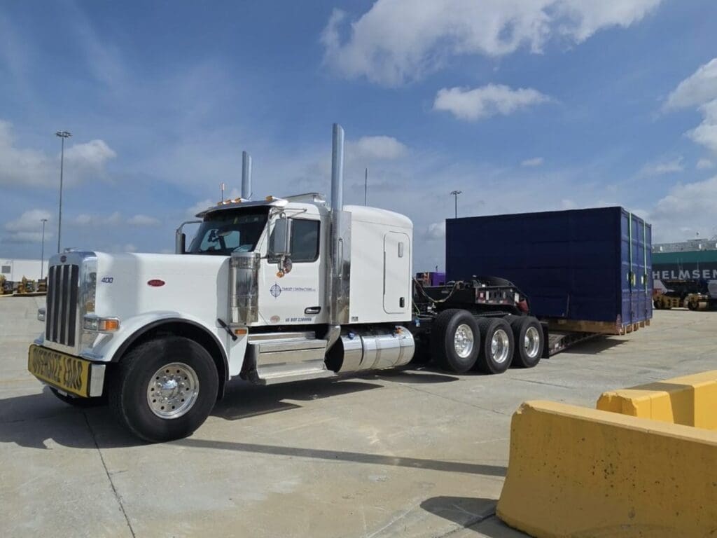 Heavy haul truck pulling a trailer carrying a container