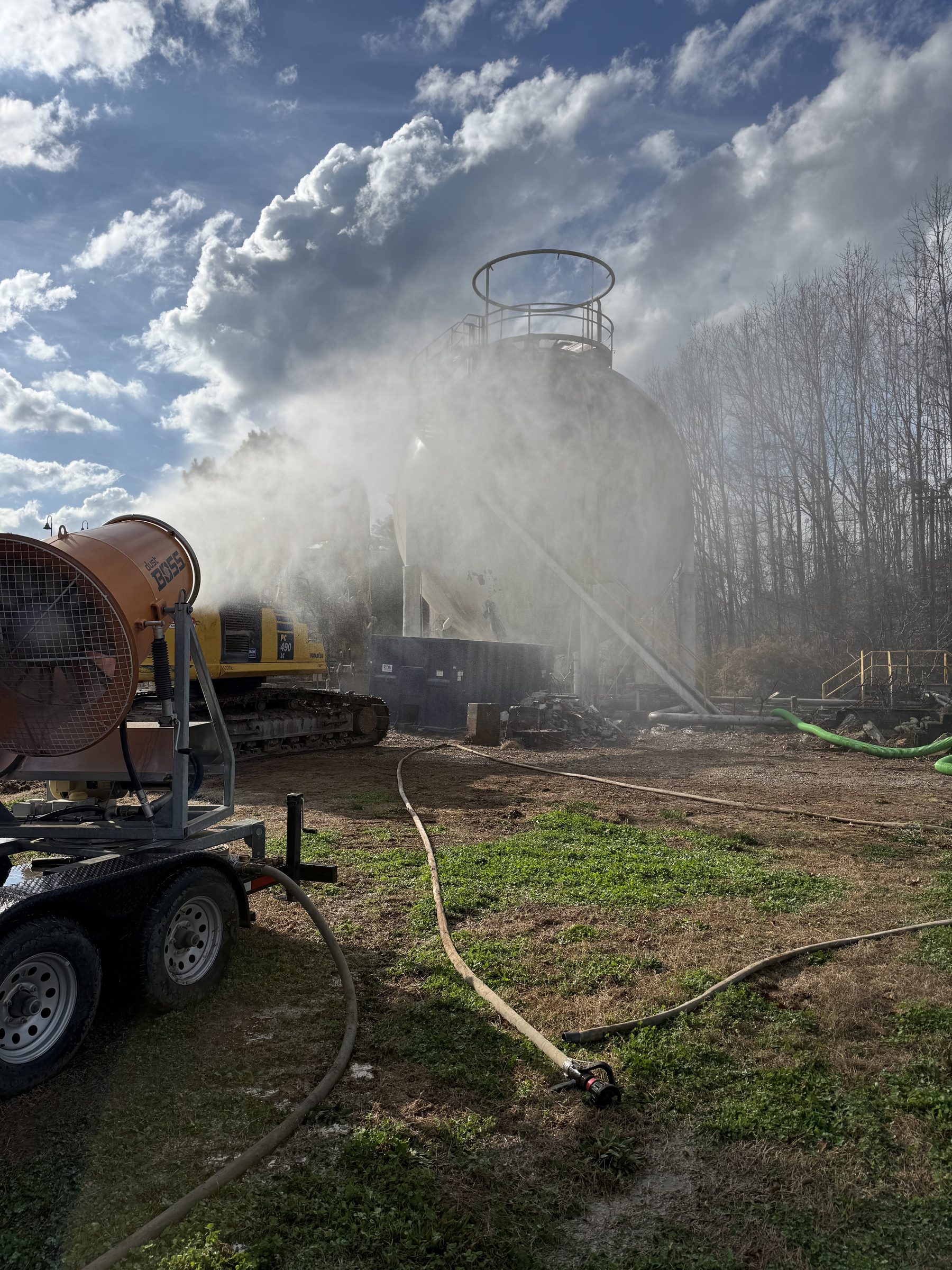 Water spray controlling dust during tank demolition
