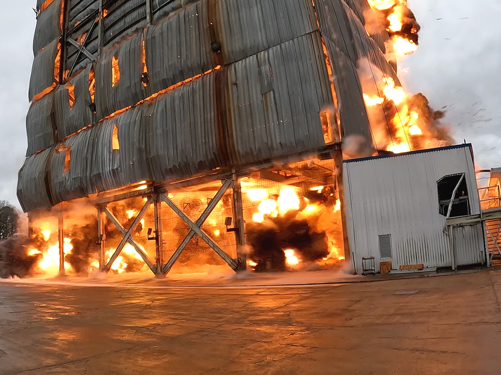 Controlled implosion at the Saturn test stand, NASA Marshall Space Flight Center, with fire and dust at the base
