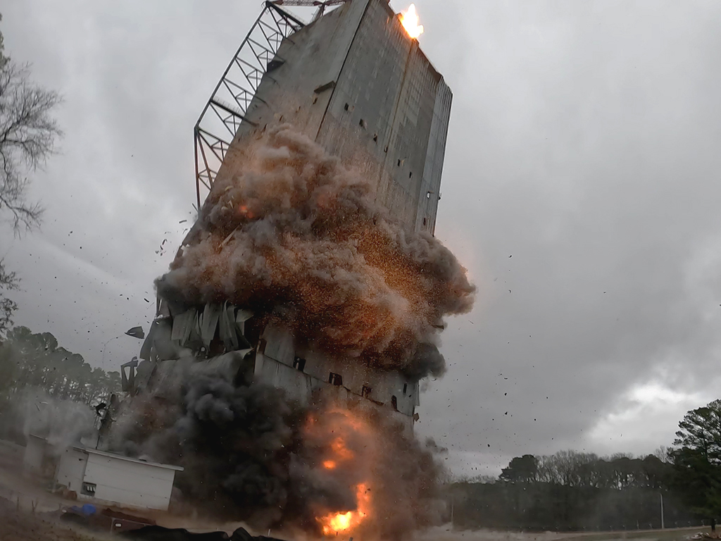 Saturn test stand tower tilting during the controlled implosion at NASA Marshall Space Flight Center